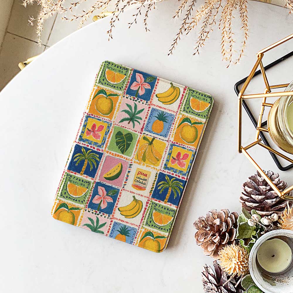 Fruit Fiesta Checkered Kindle design featuring stamps with fruits like orange, banana, pineapple, dragon fruit, watermelon, and mango, with colorful backgrounds in blue, yellow, pink, and red