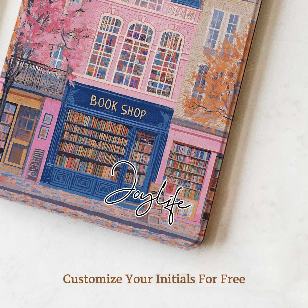 Design for a Kindle softcolor case featuring an illustration of a pink building with a blue roof and white-framed windows. In front, a bookshelf labeled 'BOOK SHOP' is displayed.