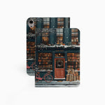 The ipad-pro-11-m4-case design features a bookstore in the snow with a red door and a black sign reading "Cherry." The store’s exterior and roof are covered in books, emphasizing its book-filled charm.
