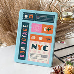 Decorative tablet stand with 'Air NYC' design on a surface with decorative elements.