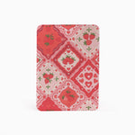 A rectangular notebook or journal with rounded corners, featuring a red and pink Valentine's Day themed pattern of strawberries, hearts, and floral tiles, shown on a plain white background.