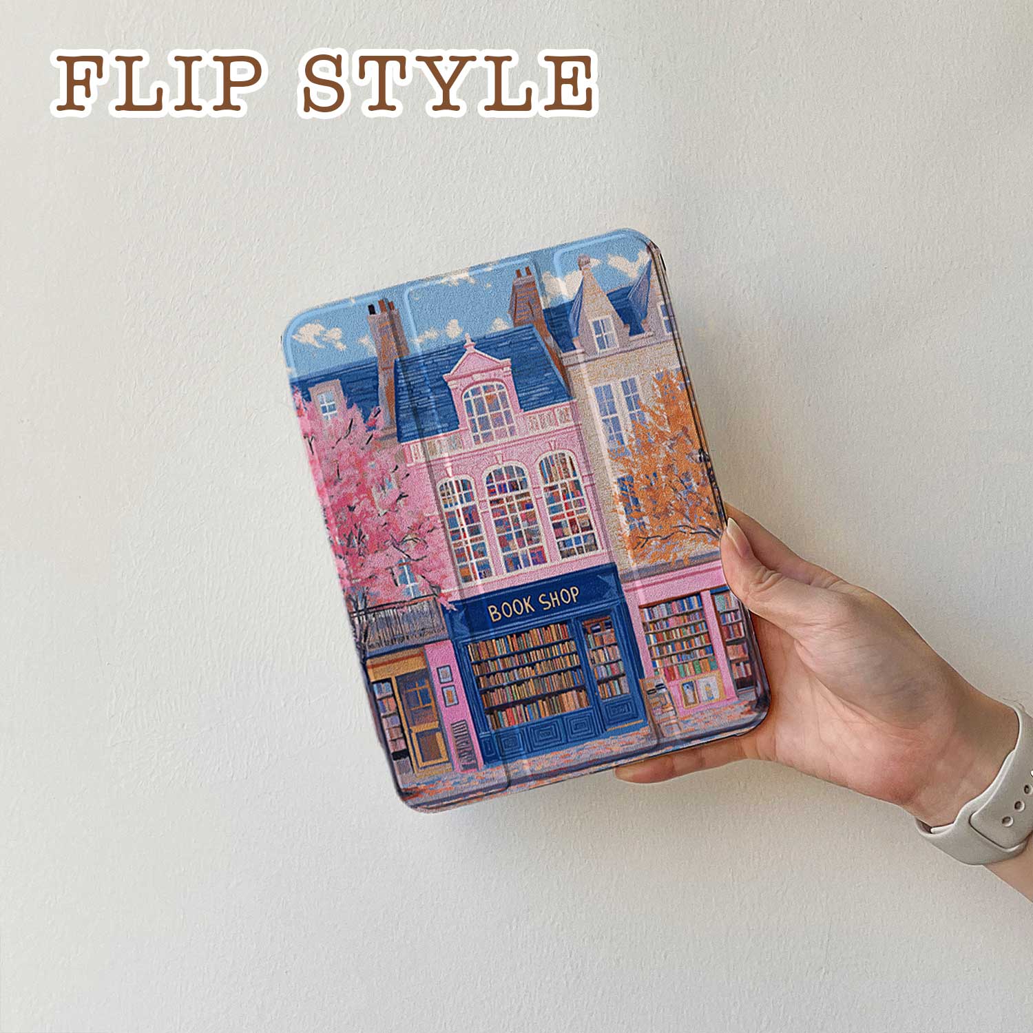 The iPad Pro M4 Case design features an illustration of a city street with vibrant buildings. The most prominent is a pink building in the center, labeled "BOOK SHOP." Large windows on the building display colorful bookshelves, creating an atmosphere full of knowledge and culture.